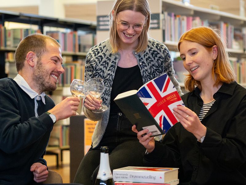 Bibliotekets litteraturformidlere skåler og kigger i en bog