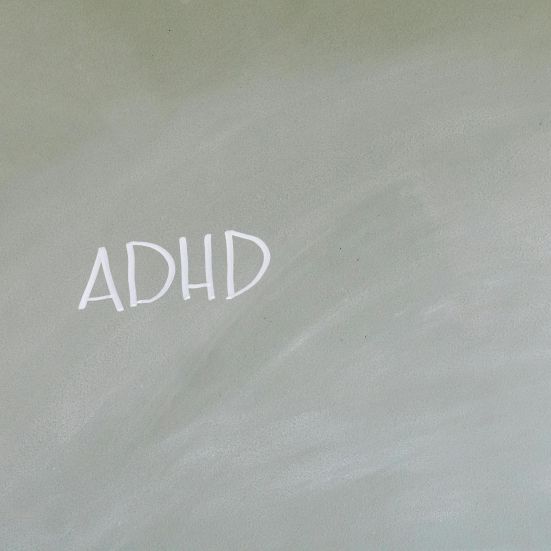 En tavle hvor der med hvidt kridt står ADHD